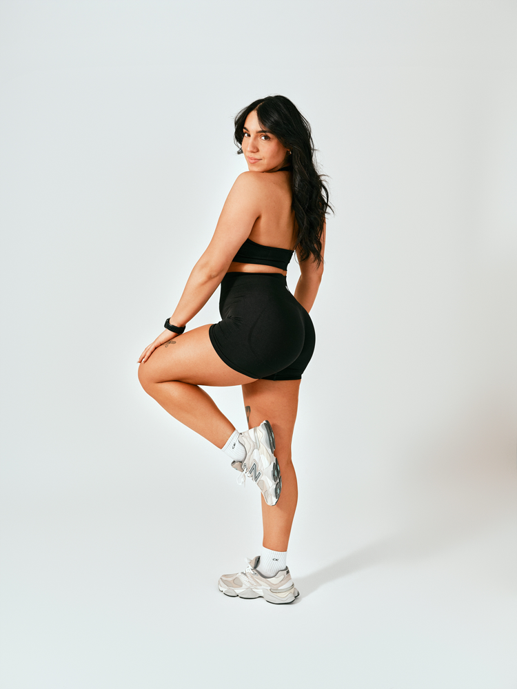 The coach is posing while standing.